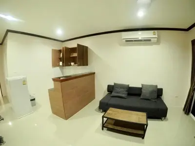 a living room with a bed and a table at KD Residence in Bang Tao Beach