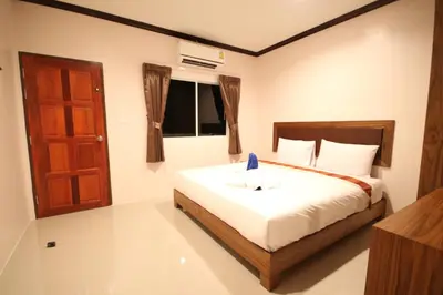 a bedroom with a bed with a brown door at KD Residence in Bang Tao Beach