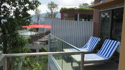 two blue chairs sitting on a balcony at 5* 3BR SUITE in Amari Phuket - Patong Beach in Patong Beach