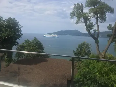 a cruise ship in the water from a balcony at 5* 3BR SUITE in Amari Phuket - Patong Beach in Patong Beach
