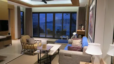 a living room with a blue couch and chairs at 5* 3BR SUITE in Amari Phuket - Patong Beach in Patong Beach