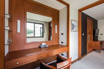 a room with a wooden vanity with a mirror at Penthouse Savoye in Ao Nang Beach