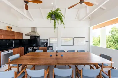 a dining room with a large wooden table and chairs at Penthouse Savoye in Ao Nang Beach