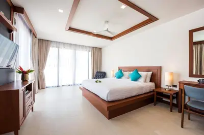 a hotel room with a bed and a television at Penthouse Savoye in Ao Nang Beach