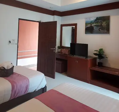 a hotel room with two beds and a television at Aromdee at Naithon Beach in Nai Thon Beach