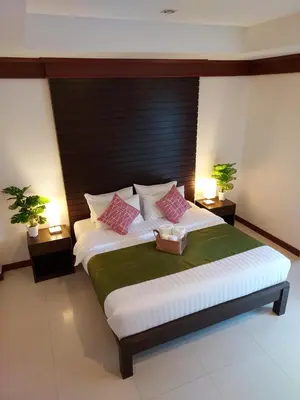 a bedroom with a large bed with pink pillows at Aromdee at Naithon Beach in Nai Thon Beach