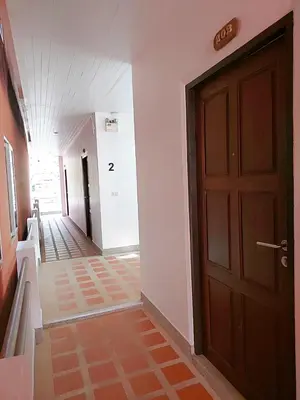 a hallway with a brown door and a hallway with stairs at Aromdee at Naithon Beach in Nai Thon Beach