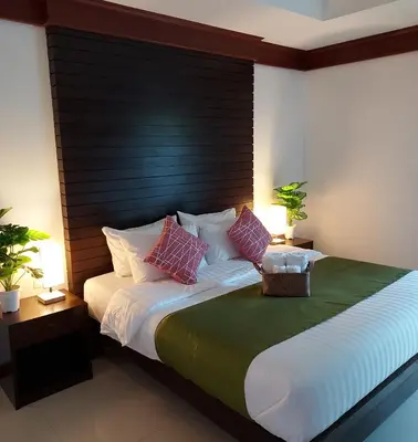 a bedroom with a large bed with a black headboard at Aromdee at Naithon Beach in Nai Thon Beach