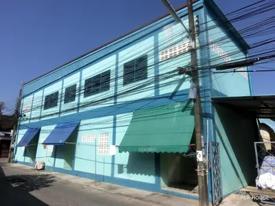 a blue building with awning on the side of it at Pek House in Phuket Town