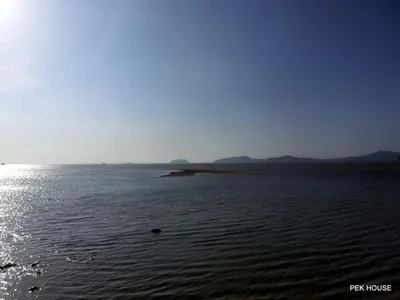 a large body of water with mountains in the background at Pek House in Phuket Town