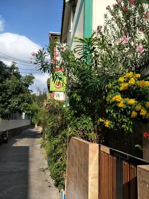 a fence with flowers on the side of a building at Phuket Green Home in Karon Beach