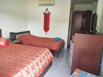 a hotel room with two beds and a tv at Phuket Green Home in Karon Beach