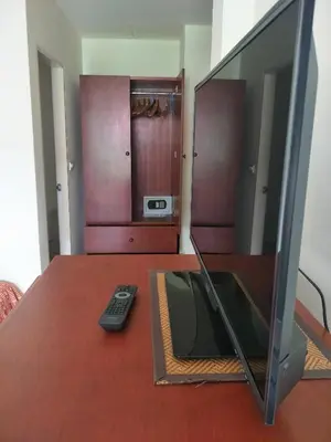a television sitting on a table with a remote control at Phuket Green Home in Karon Beach