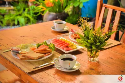 a table with a plate of food and two cups of coffee at The Orange City Resort in Ao Nang Beach