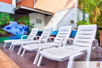 a row of white chairs sitting in front of a mural at The Orange City Resort in Ao Nang Beach