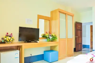 a room with a television on a desk with flowers at The Orange City Resort in Ao Nang Beach