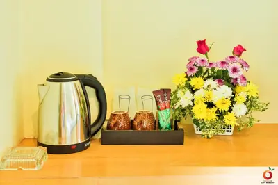 a table with a coffee pot and flowers on it at The Orange City Resort in Ao Nang Beach