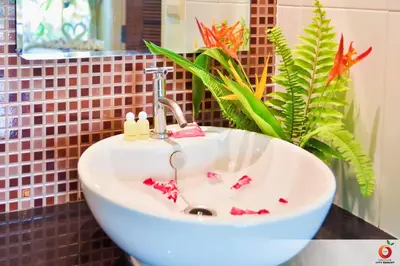 a white sink in a bathroom with a plant at The Orange City Resort in Ao Nang Beach
