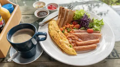 a plate of food with a sandwich and salad and a cup of coffee at 8IK88 Resort, Phuket - SHA Extra Plus in Por Bay
