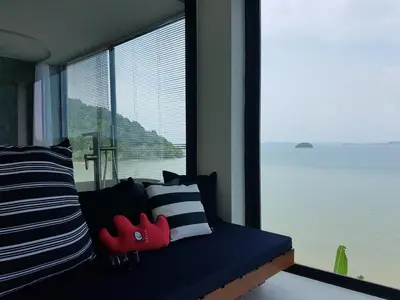 a room with a couch with a large window at 8IK88 Resort, Phuket - SHA Extra Plus in Por Bay