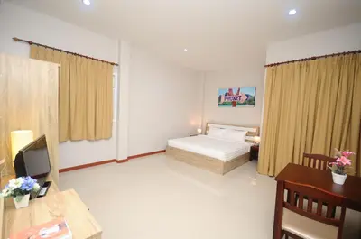 a hotel room with a bed and a desk and a desk at Maikhao Beach Residence in Mai Khao Beach