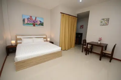 a bedroom with a bed and a desk and a table at Maikhao Beach Residence in Mai Khao Beach