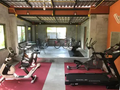 a gym with bikes and exercise equipment in a room at Maikhao Beach Residence in Mai Khao Beach