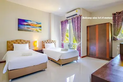 a bedroom with two beds and a window at Maikhao Beach Residence in Mai Khao Beach