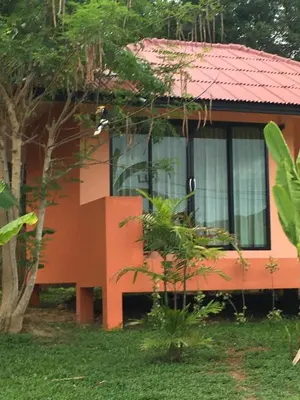 a orange house with a red roof and a tree at Baansuan Amaleena in Ko Yao Noi