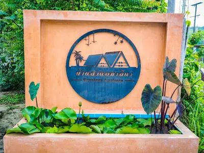 a sign in a box with plants in a garden at Baansuan Amaleena in Ko Yao Noi