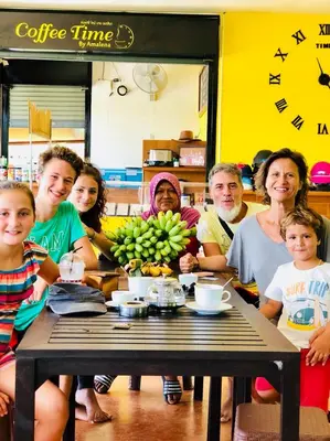 a group of people sitting around a table with bananas at Baansuan Amaleena in Ko Yao Noi