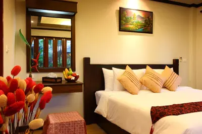 a bedroom with two beds and a window and flowers at Pai Tan Villas - SHA Extra Plus in Bang Tao Beach