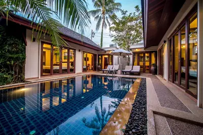 a house with a swimming pool next to a building at Pai Tan Villas - SHA Extra Plus in Bang Tao Beach