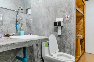a bathroom with a white toilet and a sink at Sunrise House in Ko Yao Noi