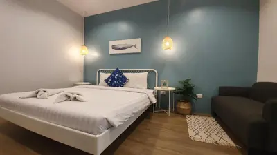 a bedroom with a bed and a couch at Wynn House in Karon Beach