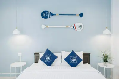 a bedroom with a bed with a baseball bat and pillows at Wynn House in Karon Beach