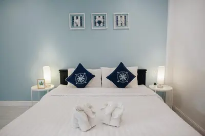 a bedroom with a bed with towels on it at Wynn House in Karon Beach