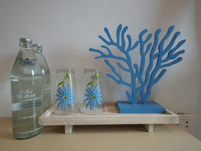 a shelf with two glass vases and a blue plant at Wynn House in Karon Beach