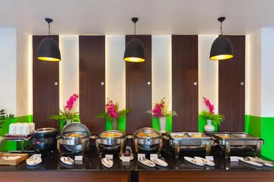 a buffet line with bowls and plates of food at Thanthip Beach Resort Patong in Patong Beach