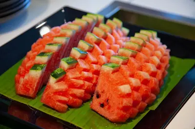 a green plate with several different types of fruit at Thanthip Beach Resort Patong in Patong Beach