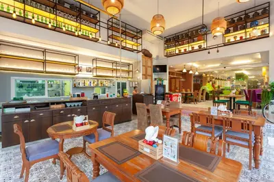 a restaurant with tables and chairs and a cafeteria at Thanthip Beach Resort Patong in Patong Beach