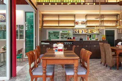 a dining room with a wooden table and chairs at Thanthip Beach Resort Patong in Patong Beach