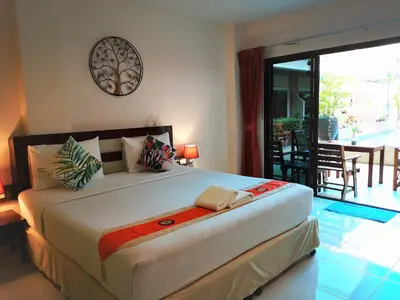 a bedroom with a large bed and a balcony at Seven Seas Hotel Patong Beach in Patong Beach