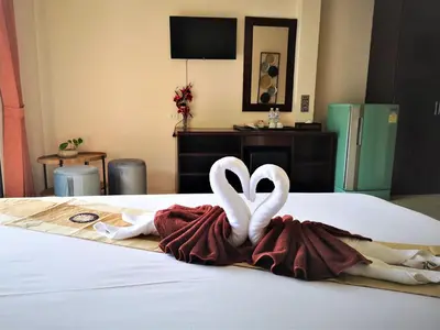 two white swans sitting on top of a bed at Seven Seas Hotel Patong Beach in Patong Beach