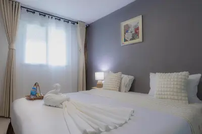 a bedroom with two beds with white sheets and a swan on them at Phi Phi Cozy Seafront Resort in Phi Phi Don