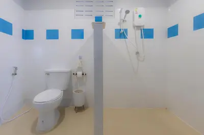 a bathroom with a toilet and a shower in it at Phi Phi Cozy Seafront Resort in Phi Phi Don