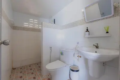 a white bathroom with a toilet and a sink at Phi Phi Cozy Seafront Resort in Phi Phi Don