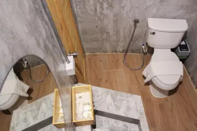 a bathroom with a toilet and a shower with a mirror at The Simple Koh Yao Noi in Ko Yao Noi