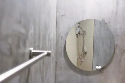 a bathroom with a round mirror and a shower at The Simple Koh Yao Noi in Ko Yao Noi