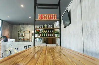a room with a wooden table and a shelf with bottles at The Simple Koh Yao Noi in Ko Yao Noi